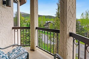 Ein Balkon mit Blick auf eine grüne Landschaft und ein Gebäude in der Ferne.