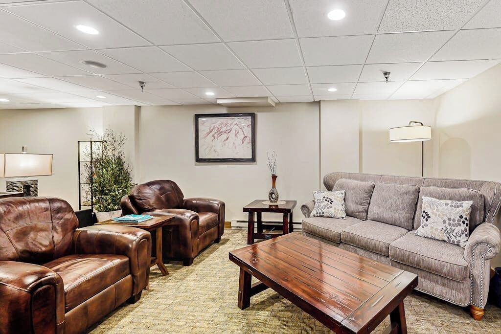 A living room with leather sofas, a wooden coffee table, and a framed picture on the wall.