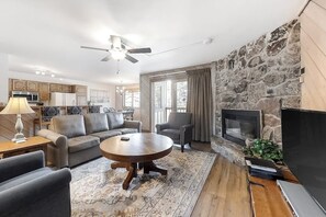 Ein Wohnzimmer mit Steinwand, Kamin und Fernseher.