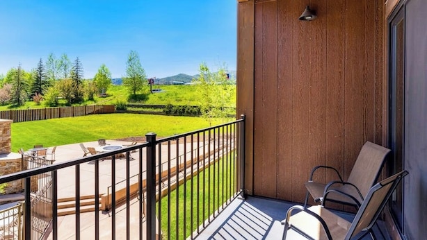 A balcony with a view of a green landscape and a clear sky. - Base area studio w/shared pool & hot tub, private balcony - steps from ski lifts (Steamboat Springs)