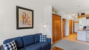 A living room with a sofa, a coffee table, and a framed picture on the wall. - Base area studio w/shared pool & hot tub, private balcony - steps from ski lifts (Steamboat Springs)