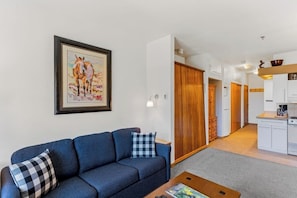 Ein Wohnzimmer mit einer Couch, einem Couchtisch und einem gerahmten Bild an der Wand.