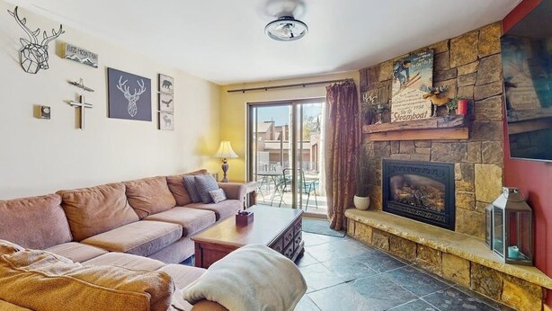 Een woonkamer met een bank, open haard en wanddecoraties.