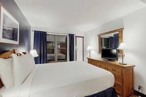 Ein Hotelzimmer mit Bett, Fernseher, Schminktisch und Spiegel.