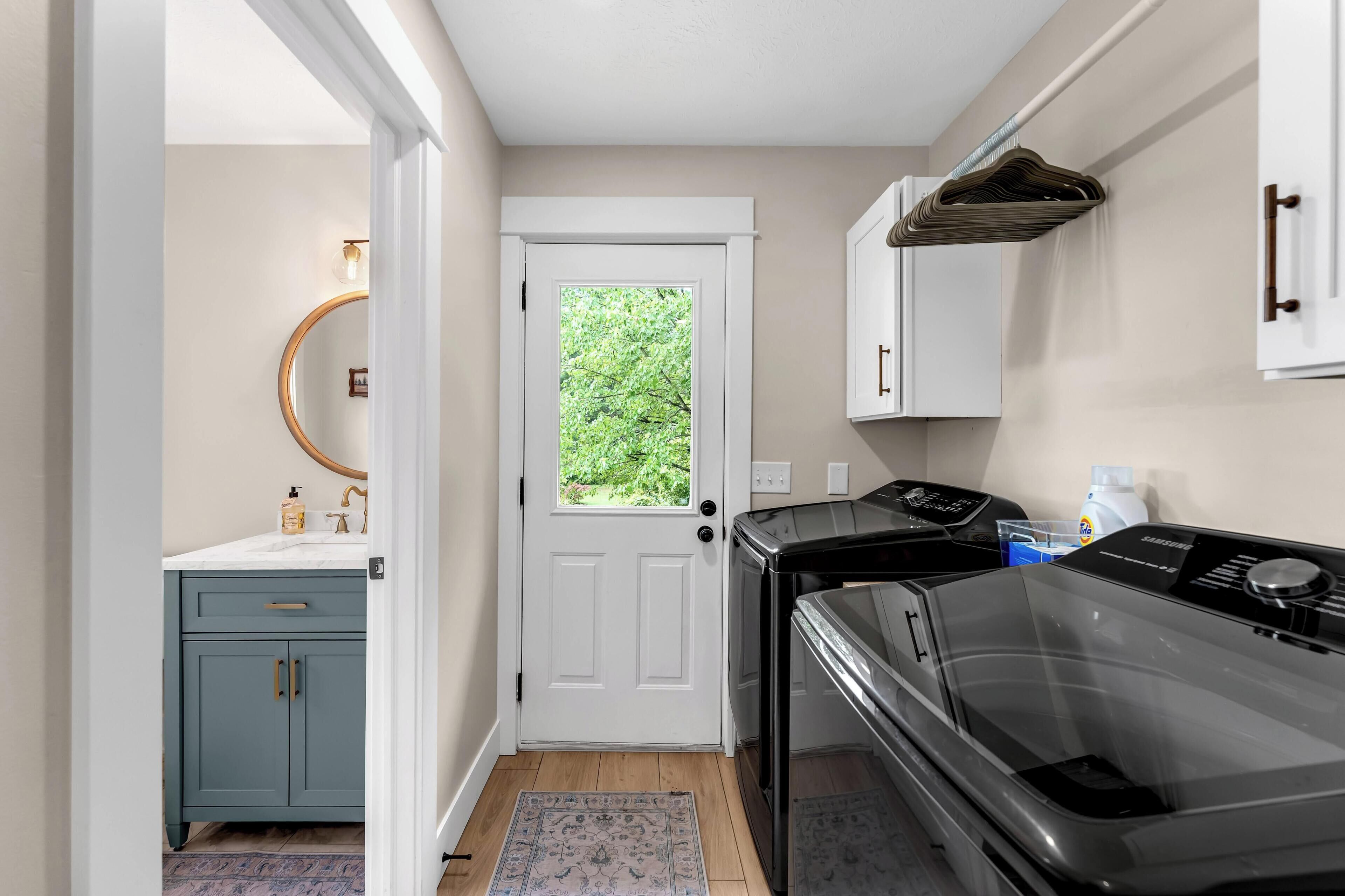 A compact kitchen with a white door, a built-in oven, and a microwave.