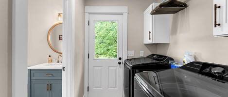 A compact kitchen with a white door, a built-in oven, and a microwave.
