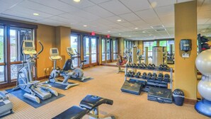 Ein Fitnessstudio mit Laufbändern, Crosstrainern, Kurzhanteln und Trainingsmatten.