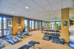 A gym with treadmills, elliptical machines, free weights, and exercise mats. - Gorgeous posh condo w/shared pool, hot tubs, fitness, game room & more (Steamboat Springs)