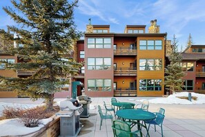 A multi-story building with balconies, outdoor seating, and snow on the ground. - Large, creekside condo w/ shared hot tubs - across the street from resort trails (Steamboat Springs)