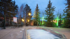 Une piscine extérieure chauffée, dotée d’une zone de sécurité de 90 cm (environ 3 pieds) et entourée d’une clôture, de chaises et d’arbres.