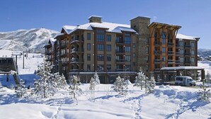 Ett hotell med flera våningar och balkonger, en skidlift i bakgrunden och ett snötäckt landskap.