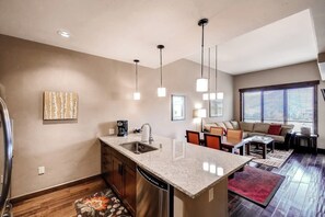 A modern kitchen with a central island, built-in dishwasher, and pendant lighting. - Impressive condo w/private balcony, gondola access, shared pool and hot tubs (Steamboat Springs)
