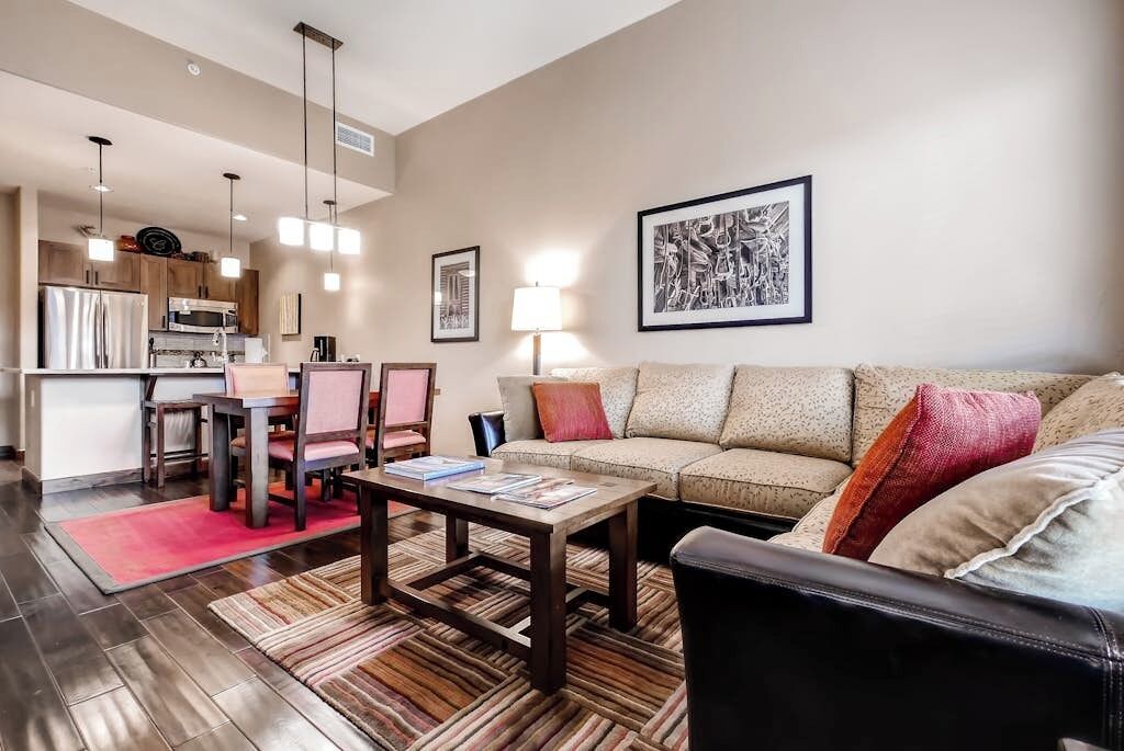 A modern living room with a sofa, coffee table, and dining area.