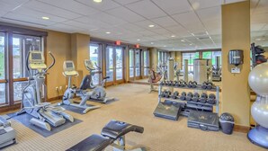 Ein Fitnessstudio mit Laufbändern, Crosstrainern, Kurzhanteln und Trainingsmatten.