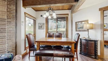 A dining area with a wooden table, leather chairs, a bench, and a cabinet.