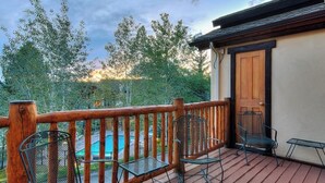Eine Holzterrasse mit Metallstühlen und einer Tür.