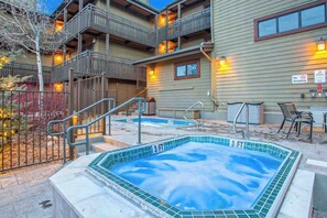 Ein Hotel mit Whirlpool, Außenbereich und einer Treppe, die zu einem Balkon führt.