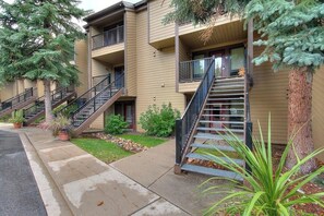 A multi-story building with external staircases, balconies, and potted plants. - Large split-level condo with valley & mountain views plus hot tubs (Steamboat Springs)