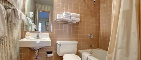 A bathroom with a sink, toilet, and bathtub.