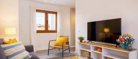 A living room with a sofa, a chair, a TV, and a coffee table.