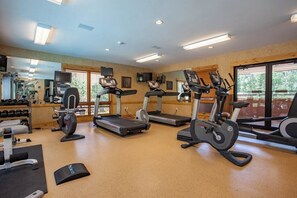 Ein Fitnessstudio mit Laufbändern, Crosstrainern und Gewichten.