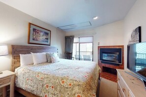 Une chambre d’hôtel avec un lit, une télévision, une cheminée et une fenêtre avec des rideaux.