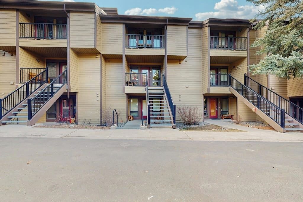 A multi-story building with balconies, staircases, and a flat entrance area.