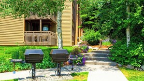 Ein Gebäude mit einem hölzernen Balkon, Solarkochgrills und einem gepflegten Garten mit Stufen zum Eingang.