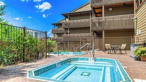 Zona de piscina con una profundidad de 0,9 metros, balcones de madera y mobiliario exterior.