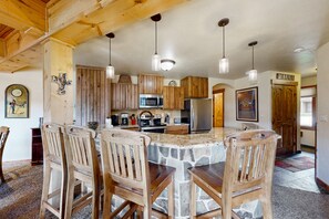 A kitchen with a central island, wooden cabinets, and pendant lighting. - The Lodge at Steamboat #C106 first-floor condo with zero stairs from parking (Steamboat Springs)