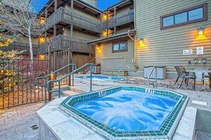 A pool area with a 3 FT depth marker, outdoor seating, and a building with balconies. - Spacious condo with pool, hot tub & washer/dryer - next to Steamboat ski lifts (Steamboat Springs)