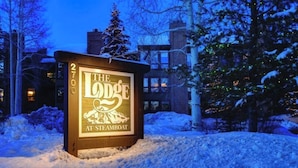 A sign for 'The Lodge at Steamboat' with a mountain and snow design. - Steamboat home with washer/dryer, pools & hot tubs - near ski lifts (Steamboat Springs)