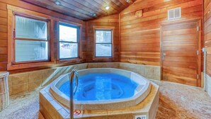A wooden cabin interior with a hot tub, large windows, and a door. - Steamboat home with washer/dryer, pools & hot tubs - near ski lifts (Steamboat Springs)
