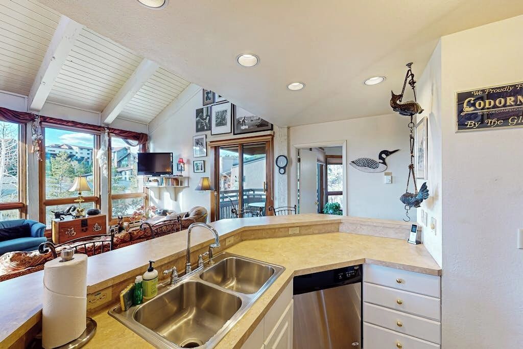 A modern kitchen with a large island, built-in appliances, and a view of the outdoors.