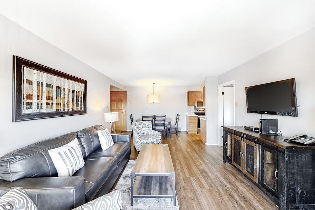 Een moderne woonkamer met een bank, salontafel en eethoek.