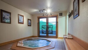 Ein Zimmer mit Whirlpool, einem Balkon mit Blick und gerahmten Bildern an den Wänden.