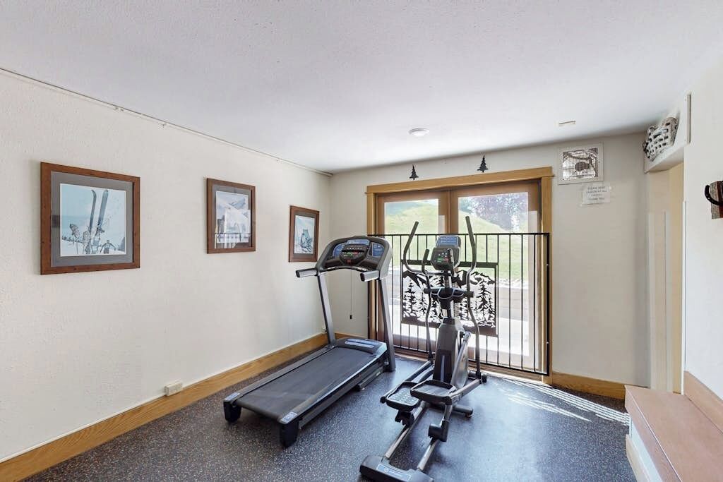 A fitness room with a treadmill, elliptical, and stationary bike.
