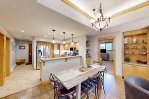 A spacious kitchen with wooden cabinets, a central island, and pendant lighting. - Spacious condo with pool, hot tub, gym & easy walk to lifts (Steamboat Springs)