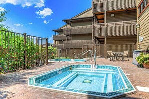 A pool area with two 3 FT pools, a wooden building with balconies, and a fenced garden. - Lovely condo with pool, hot tub, washer/dryer - 1 block to Steamboat Ski Lifts (Steamboat Springs)