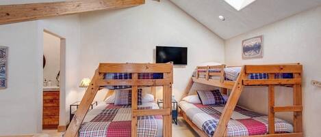 Una habitación con literas, televisión y tragaluz.