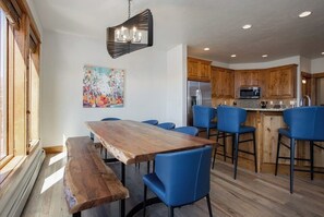 A modern kitchen with wooden cabinets, a stainless steel refrigerator, and a blue bar stool. - EagleRidge 1461 Spacious Corner Home w/ Incredible View, Free WiFi, Private Hot Tub & Large Deck (Steamboat Springs)