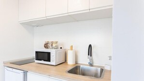 A kitchen with a microwave, a sink, and a countertop. - Checha Ático (Candelaria)