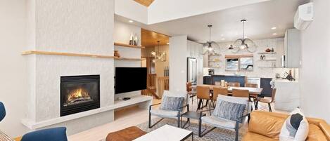 Una sala de estar moderna con chimenea, televisor y zonas de estar.