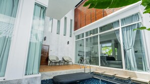 A modern indoor pool with clear glass walls, a wooden deck, and a lounge area with chairs. - NEW Lavender Private Pool Villa, Rawai , Phuket (Nai harn, Rawai)