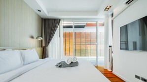 A hotel room with a large bed, a flat-screen TV, and a sliding glass door leading to a balcony. - NEW Lavender Private Pool Villa, Rawai , Phuket (Nai harn, Rawai)