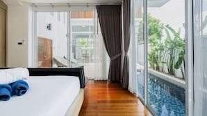 A hotel room with a bed, a view of a swimming pool, and a sliding door leading to a balcony. - NEW Lavender Private Pool Villa, Rawai , Phuket (Nai harn, Rawai)