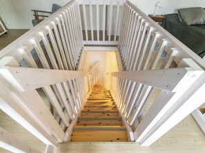 A wooden staircase with white railings leading to an upper floor.