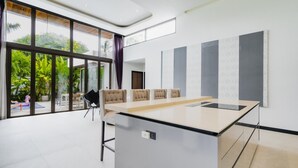 Uma sala de reuniões moderna com uma mesa comprida, cadeiras e janelas grandes.