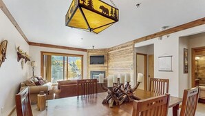 A dining area with a wooden table, chairs, and a unique centerpiece. - Updated, Second-Floor Condo with WiFi, Mountain Views, Outdoor Pool, & Hot Tub (Steamboat Springs)