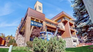 A modern building with a sign for 'Snow Flower Condominium.' - Updated, Second-Floor Condo with WiFi, Mountain Views, Outdoor Pool, & Hot Tub (Steamboat Springs)